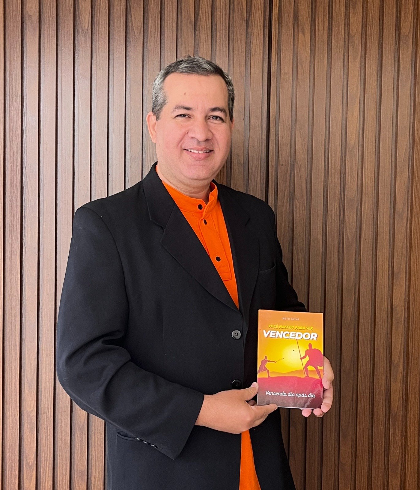 Cláudionor Lopes da Silva Neto segurando o livro Você nasceu para ser vencedor